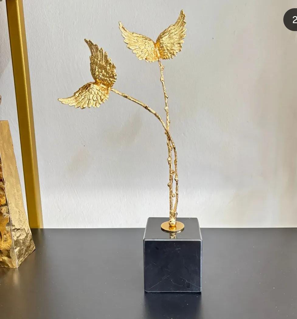 2 gold wings on black marble