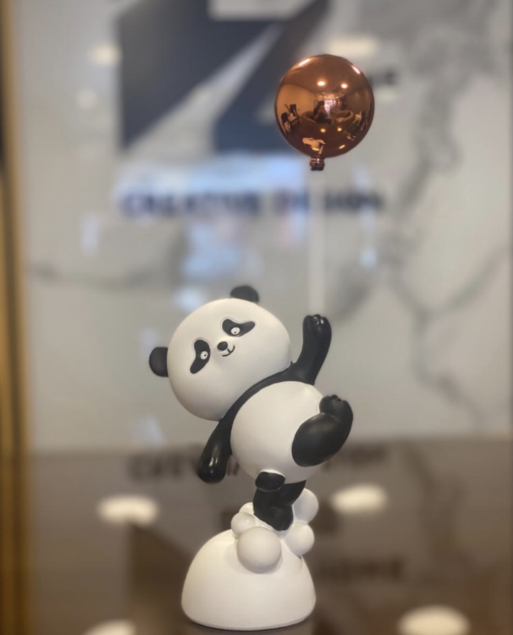 cute panda figurine holding a balloon